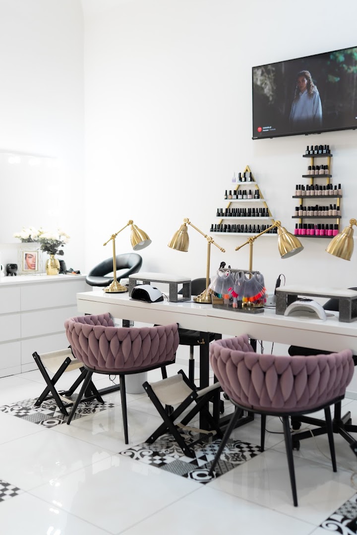 Wnetrze Pracowni Beauty z pudrowymi fotelami i scianka z lakierami